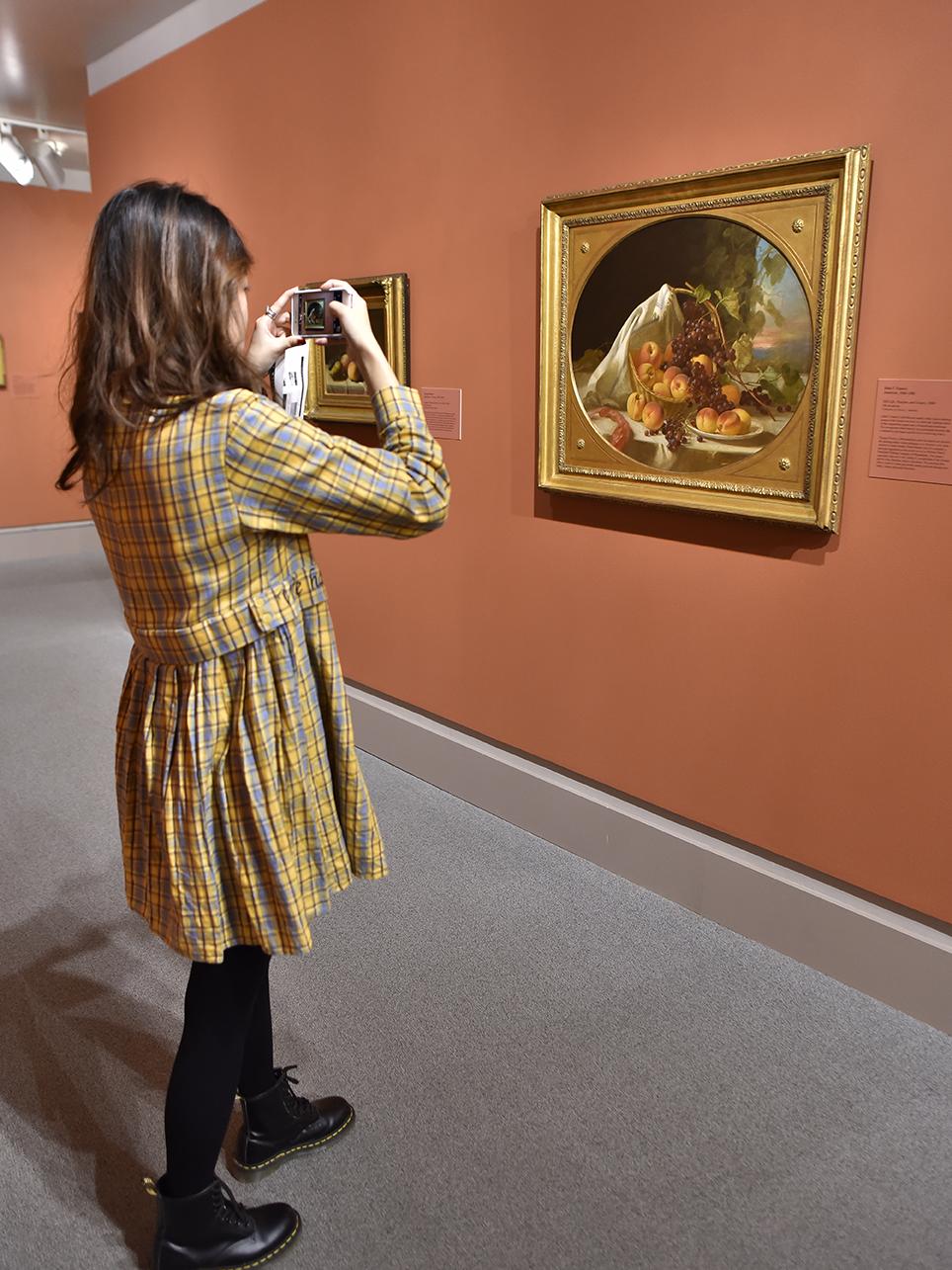 A student photographs a still-life from "Object Lessons"