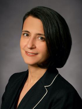 A faculty member wearing a black top smiles for a professional headshot.