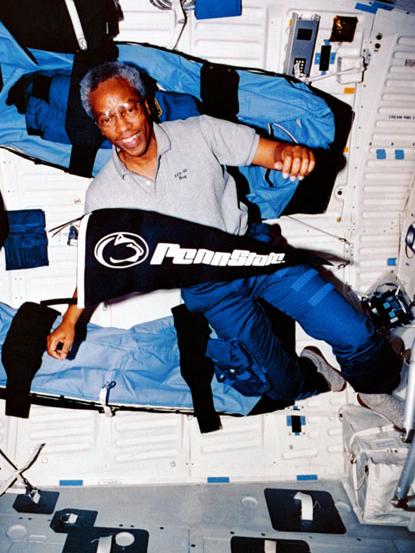 Guy Bluford in space with Penn State banner
