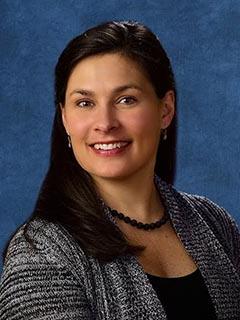 woman with dark hair poses and smiles for professional photo