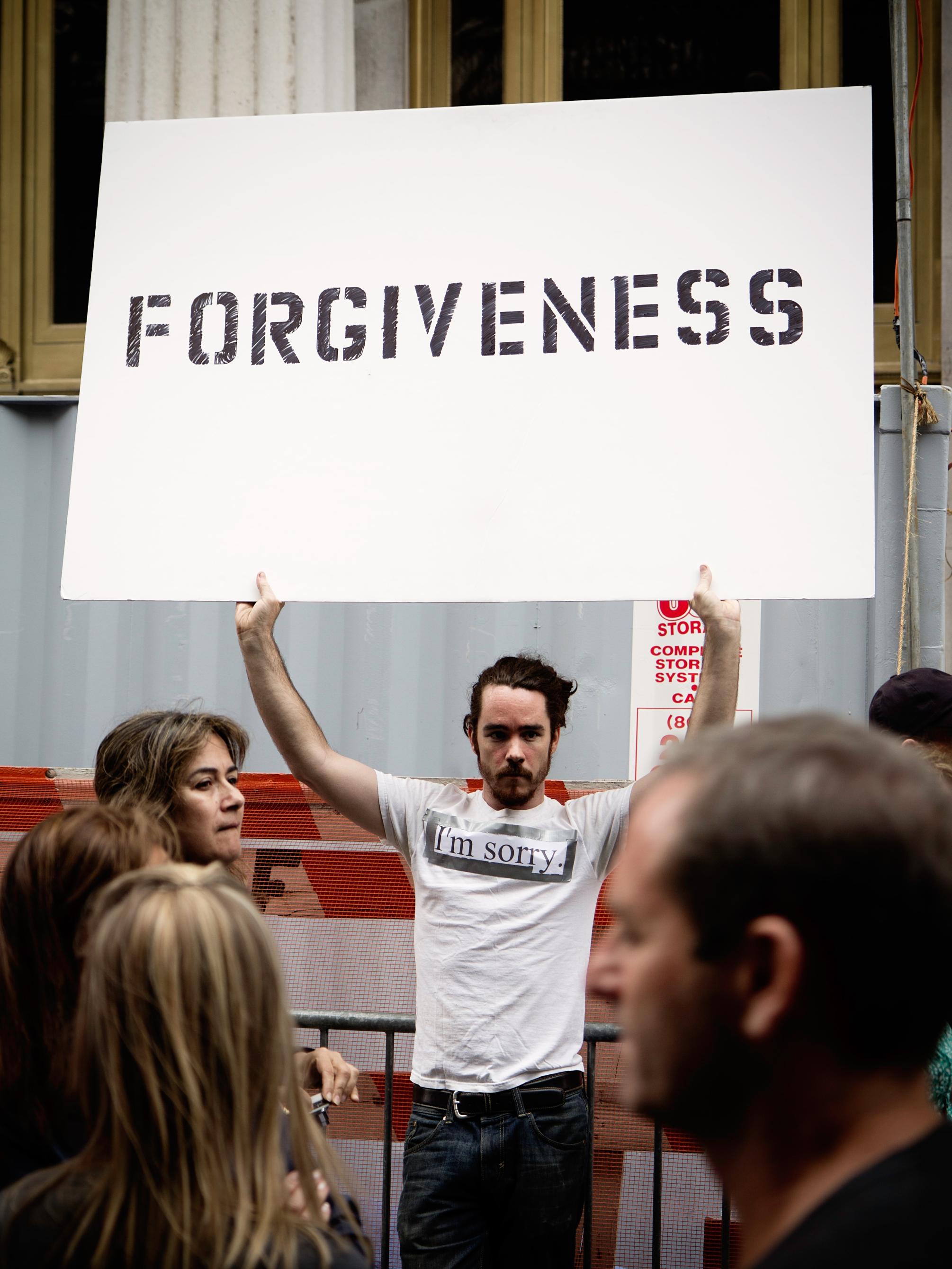 Man holding forgiveness sign