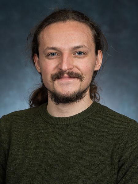 A headshot of Jasper Sachsenmeier wearing a black shirt.