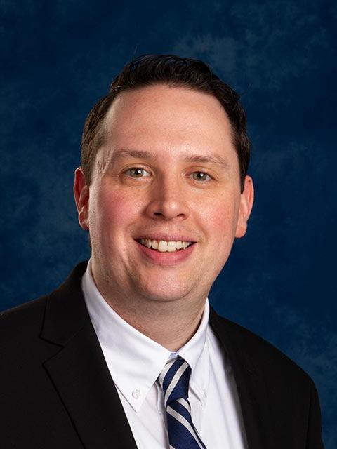 Robert Knight Jr. in dark suit and tie with white shirt.
