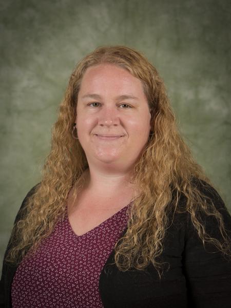 Loisa Holmes headshot in black cardigan, maroon top, long blonde hair.