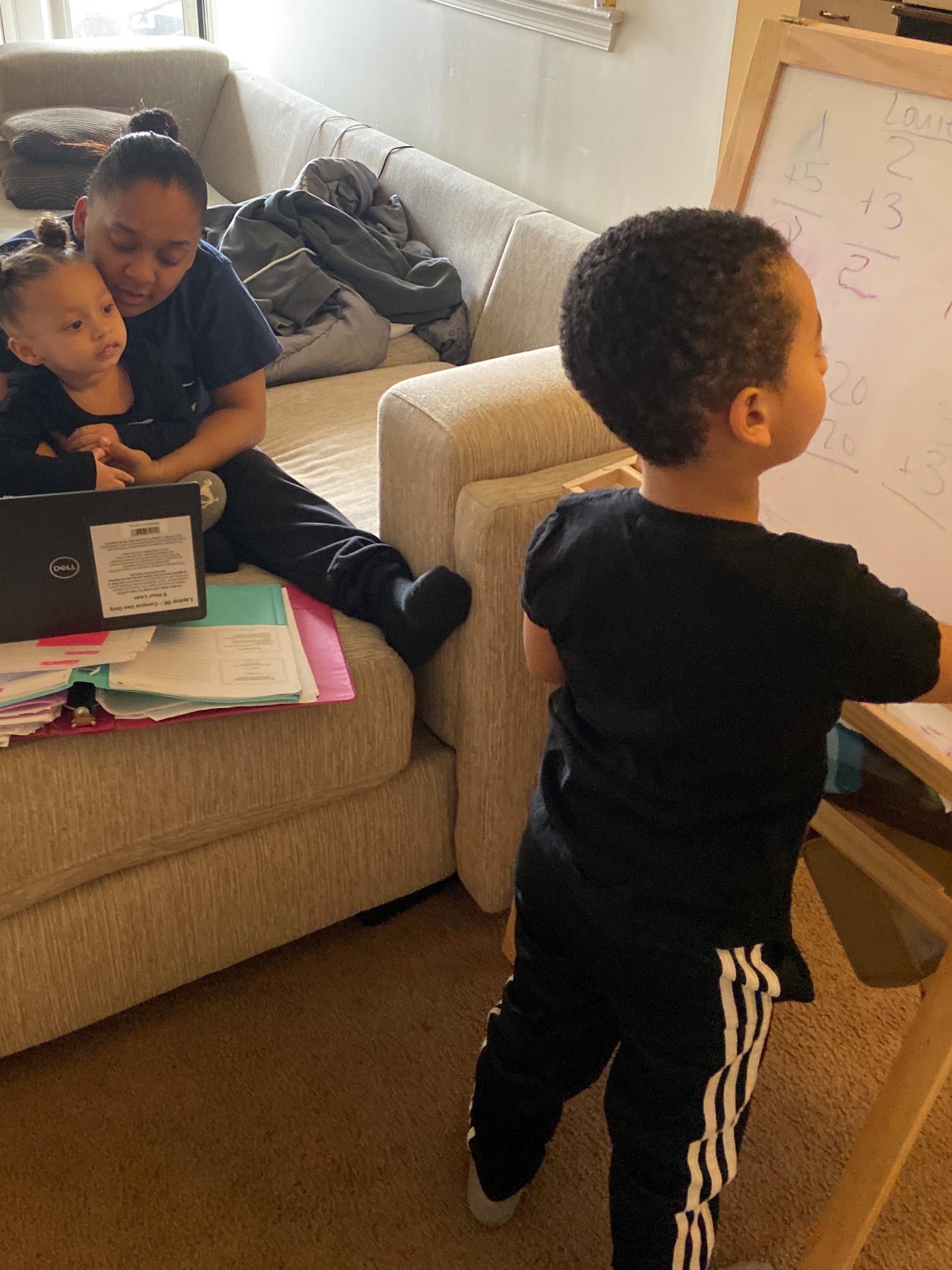 woman and her two kids at home near laptop