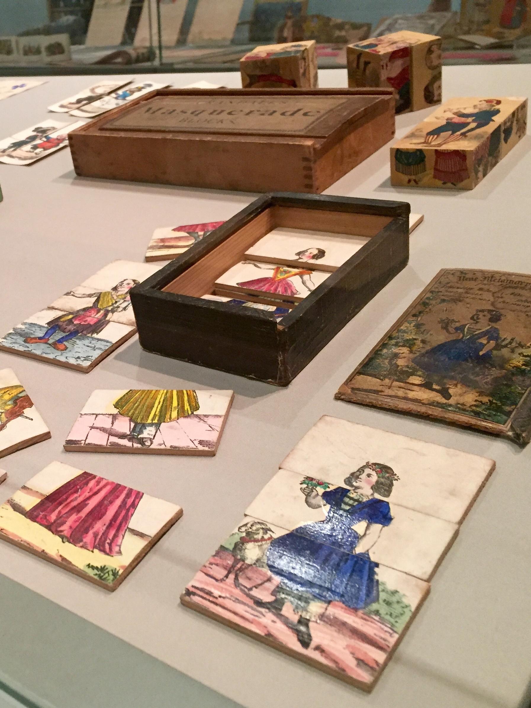 vertical images of wooden play blocks showing segmented prints of colored illustrations of girl with various articles of clothing