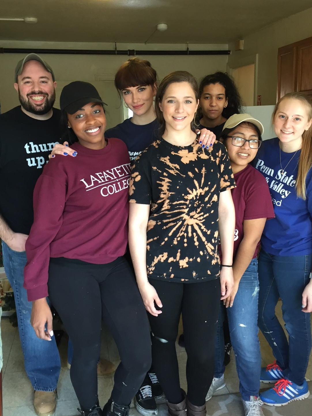 Group of students and staff member posing while volunteering