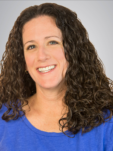 Miranda Kaye head shot with long, dark hair and blue shirt.