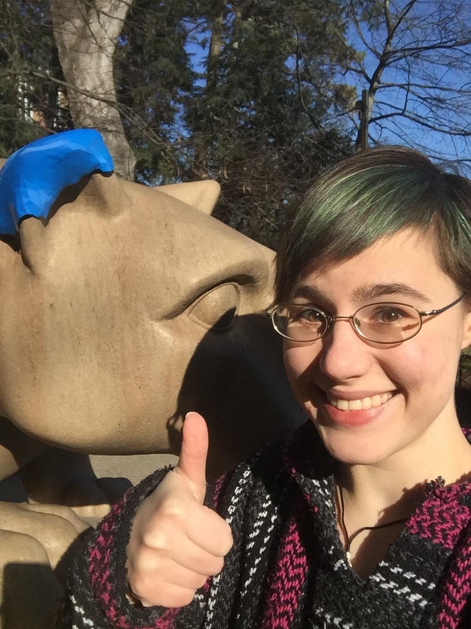Anne Pauley with the 3D-printed replacement ear that was temporarily added to the Lion Shrine in University Park, Pa.