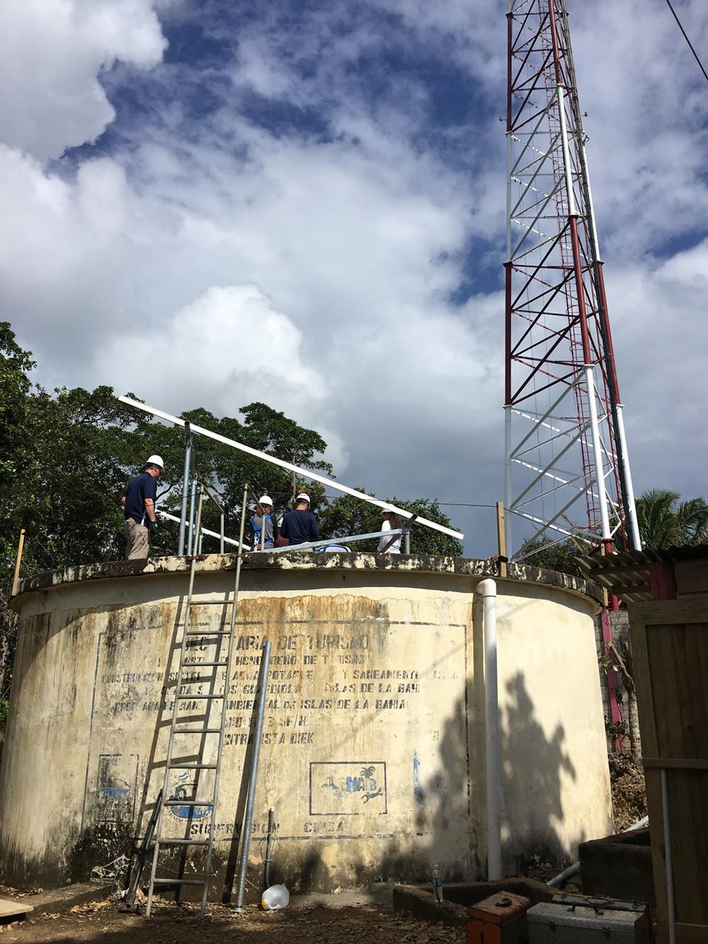 students standing on community water cistern