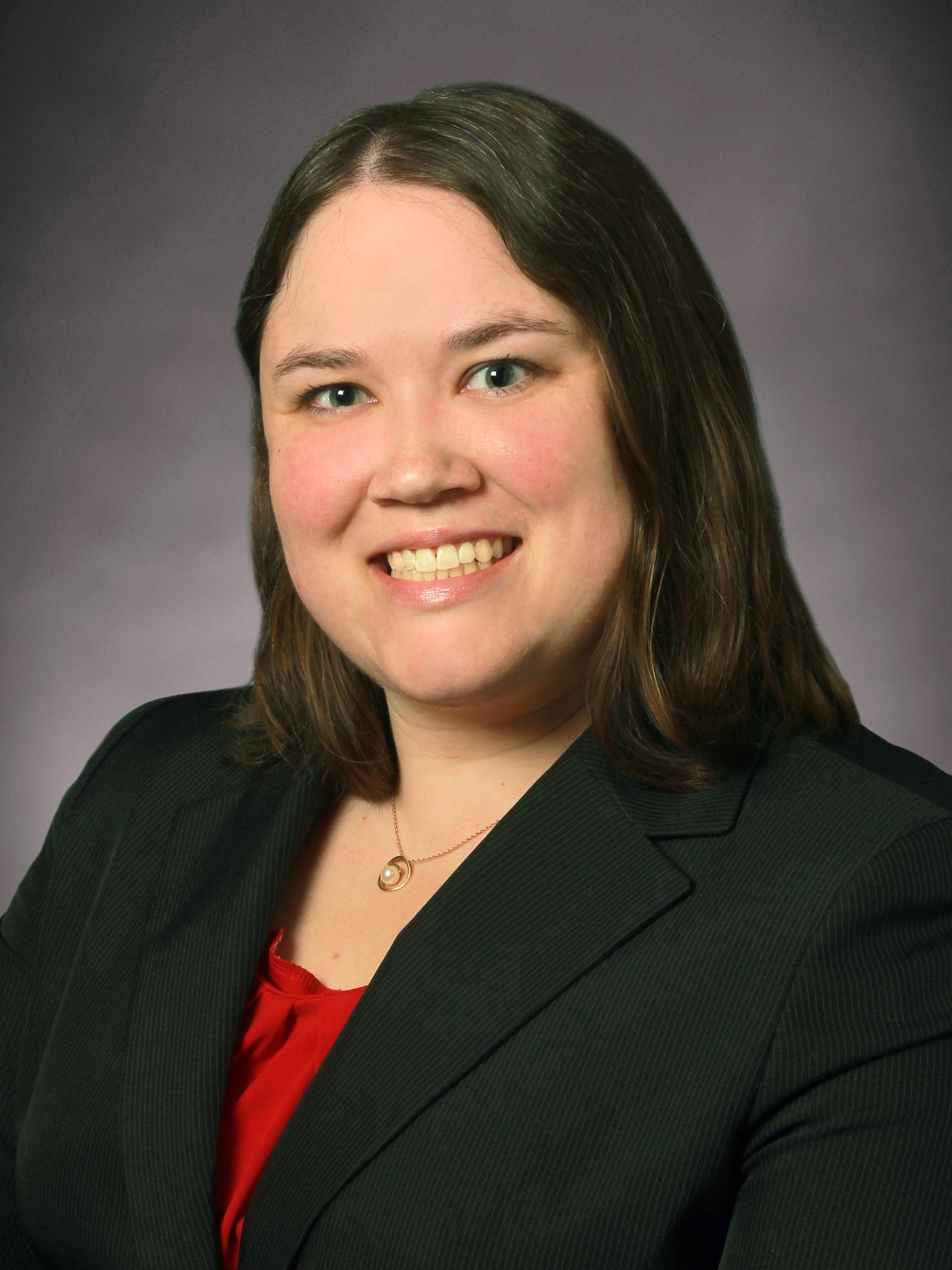Woman dressed in business attire, smiles for a professional headshot