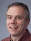 White man looking forward and smiling
