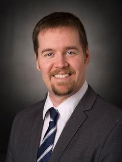 A headshot of a smiling Caucasian man. 