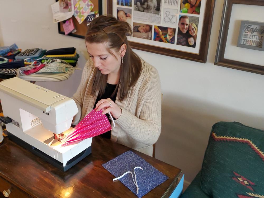 Torie Shapter sewing masks at sewing machine. 