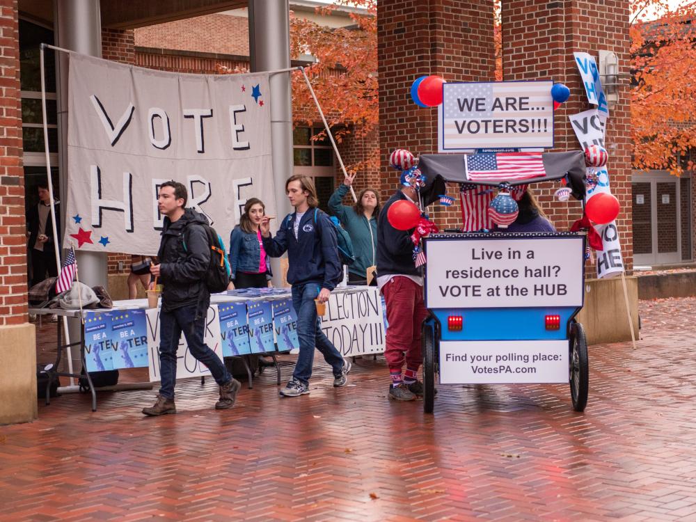 students encouraging voters on election day outside the HUB