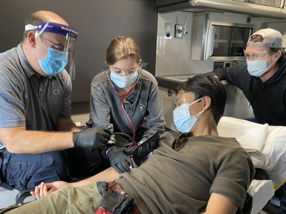 Brent Smith instructs students in Kinesiology 303: Emergency Care to take patient vital signs while in a moving ambulance.