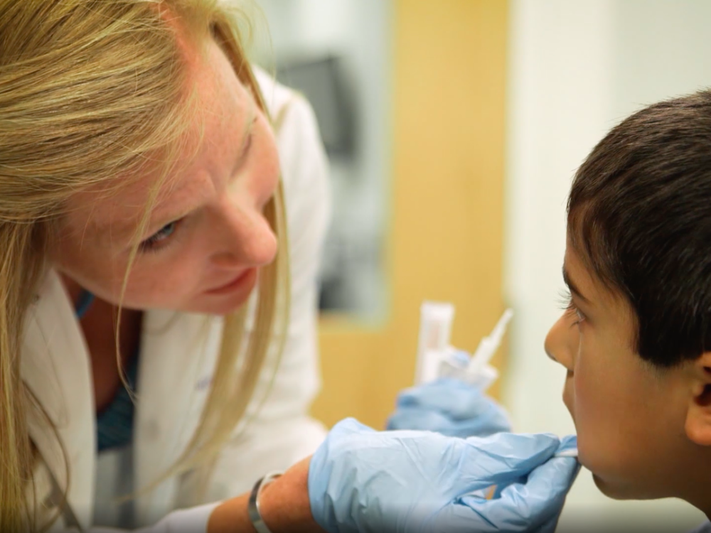 nurse takes a cheek swab from a child