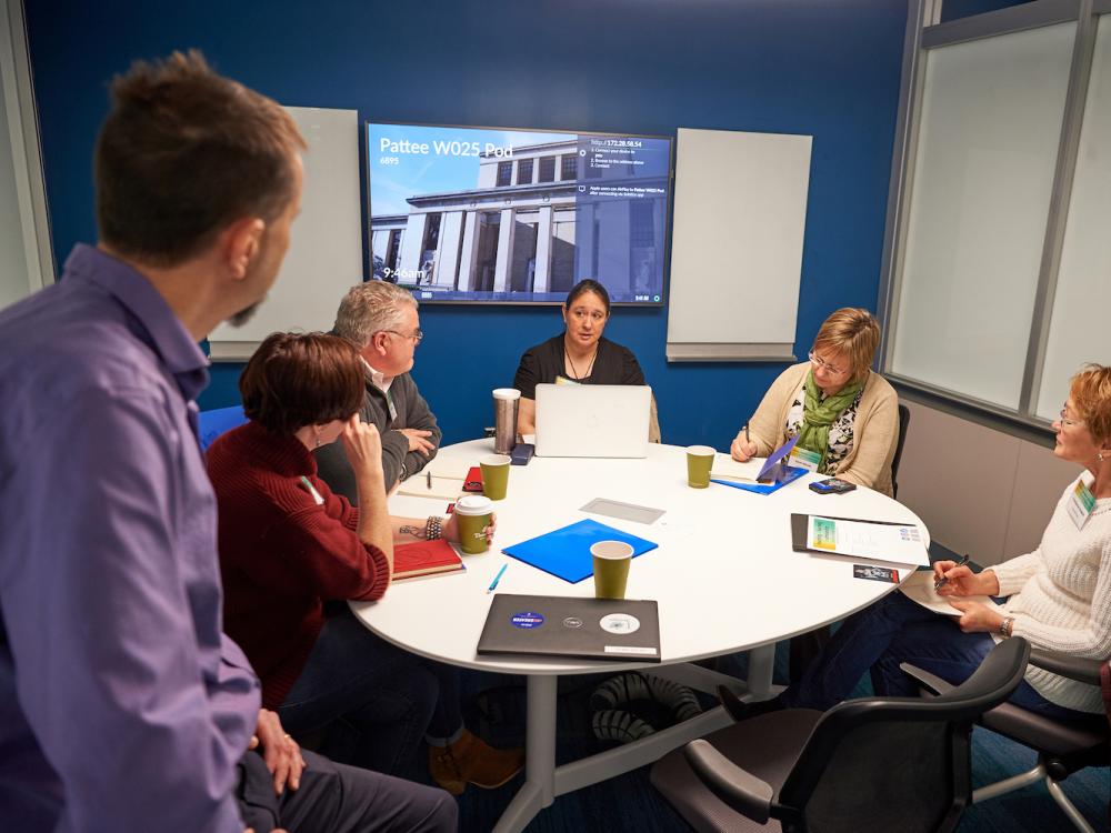 Group of people sitting around small conference table