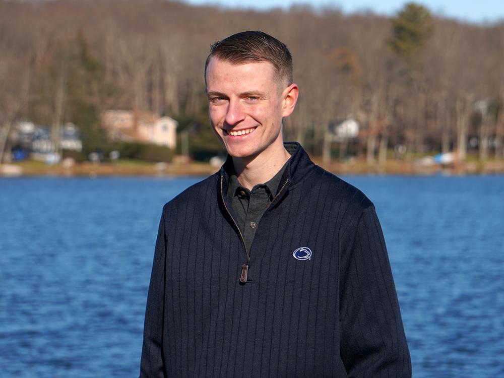 Student in Penn State sweatshirt standing in front of lake