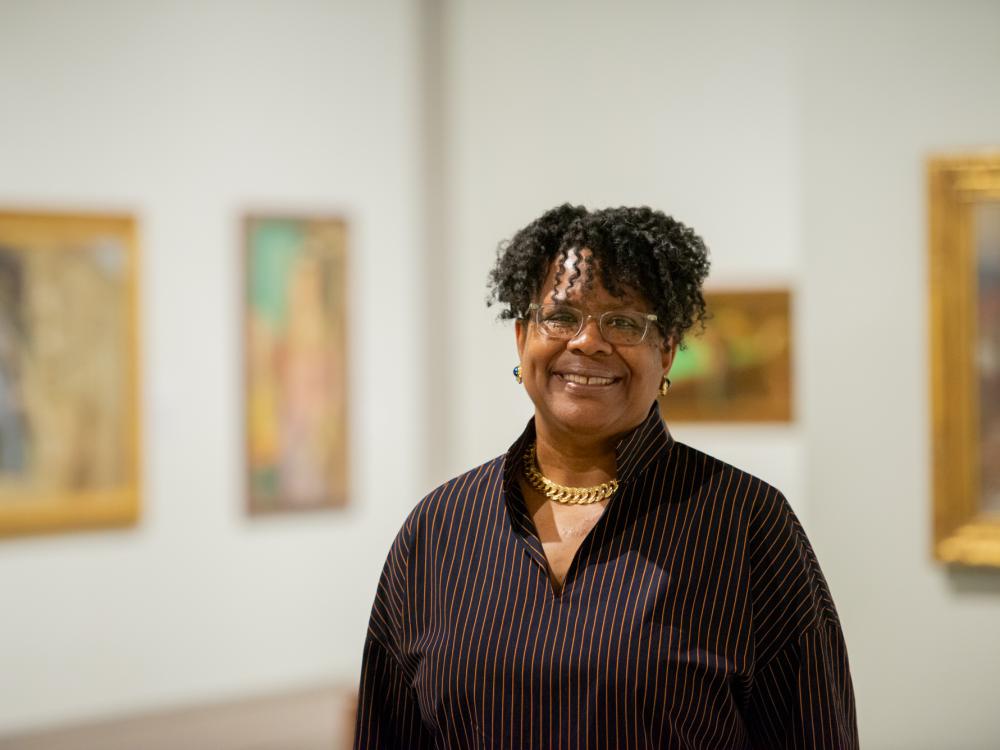Danielle M. Conway, Dean and Donald J. Farage Professor of Law at Penn State Dickinson Law, stands in an art gallery surrounded by paintings.