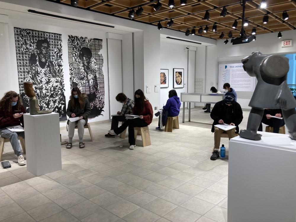 students sitting in the gallery drawing