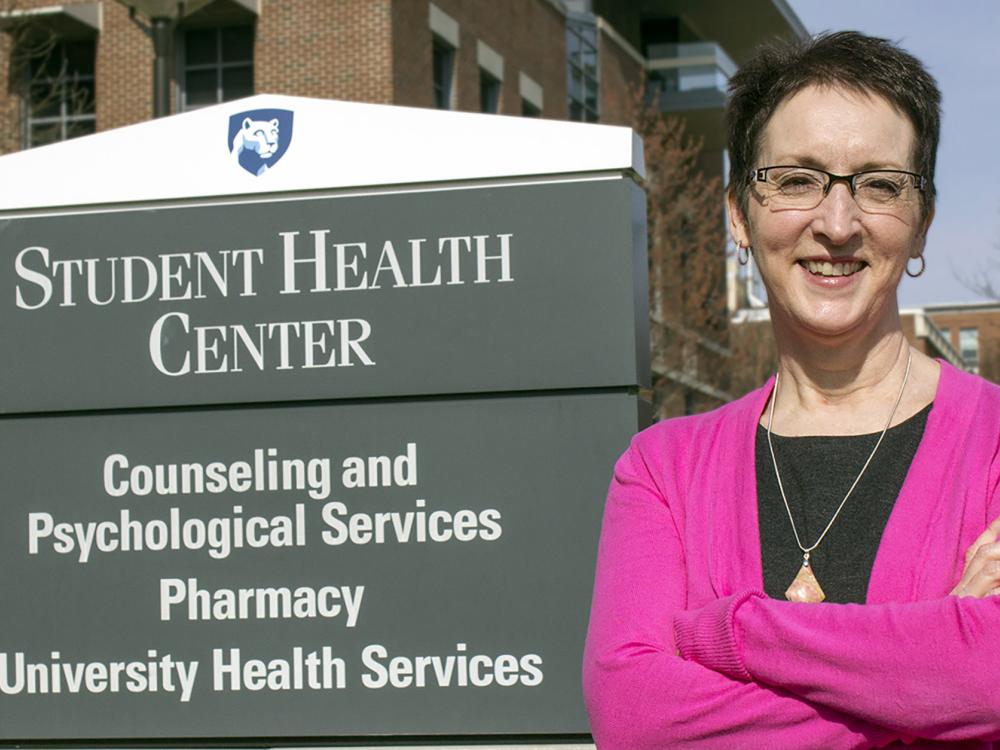 Shelley Haffner stands in front of a sign that reads "Student Health Center" in 2015