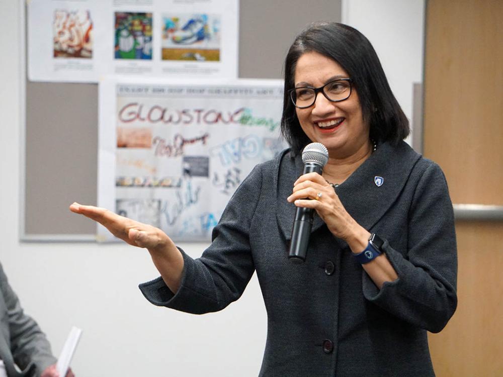 President-elect Neeli Bendapudi speaks into a microphone inside a classroom