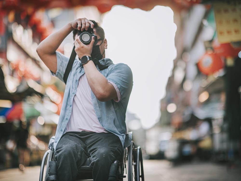 Man in wheelchair taking a photograph