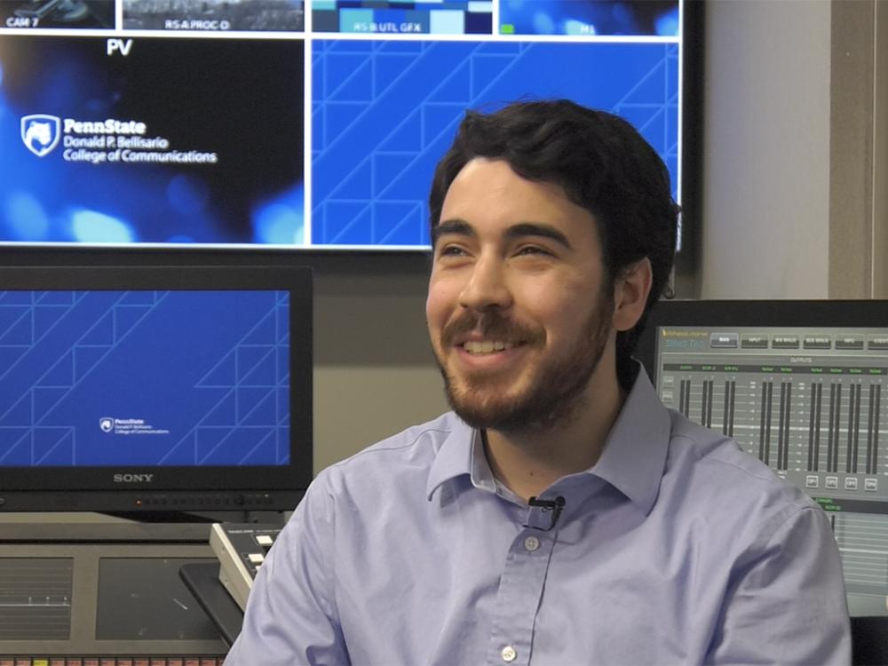 Michael Smedley smiling while seated in a in recording studio