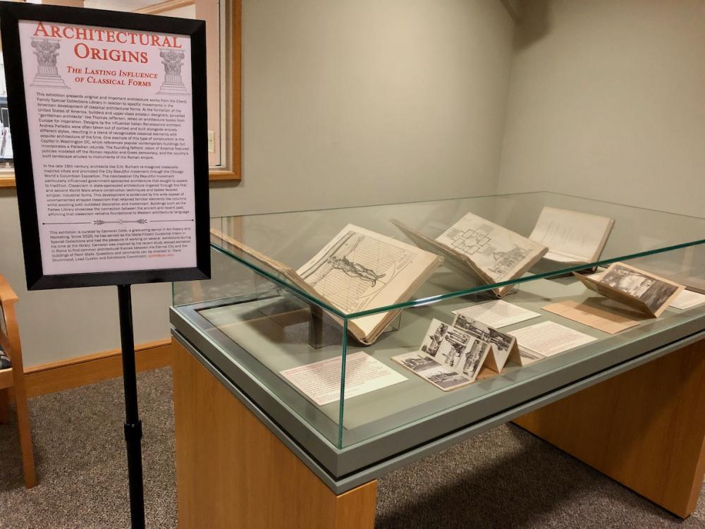 counter height glass display case with open books and documents