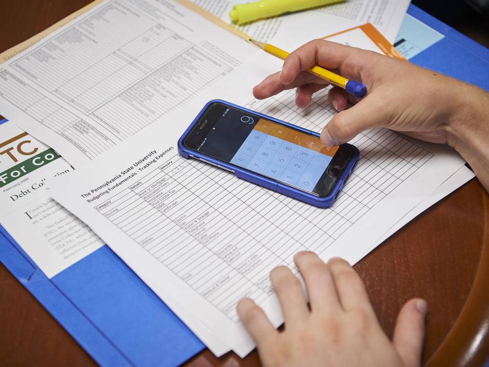 Person creating budget using paper and calculator