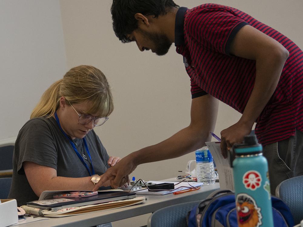 A teacher looks at Raspberry Pi computer parts while learning about coding