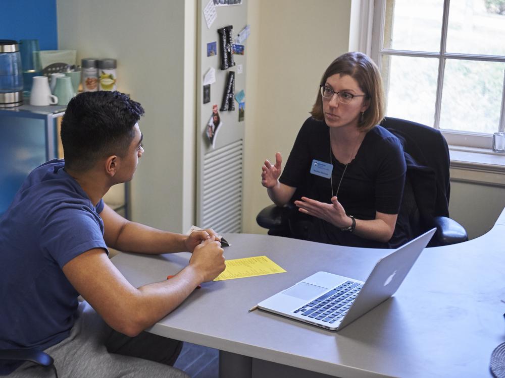 Student talking with academic adviser in an office