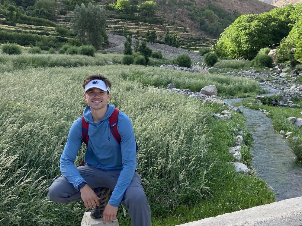 Nate Cherok posing in front of farmland and mountains in Morocco