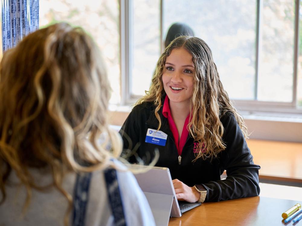 Orientation leader at computer helping new student