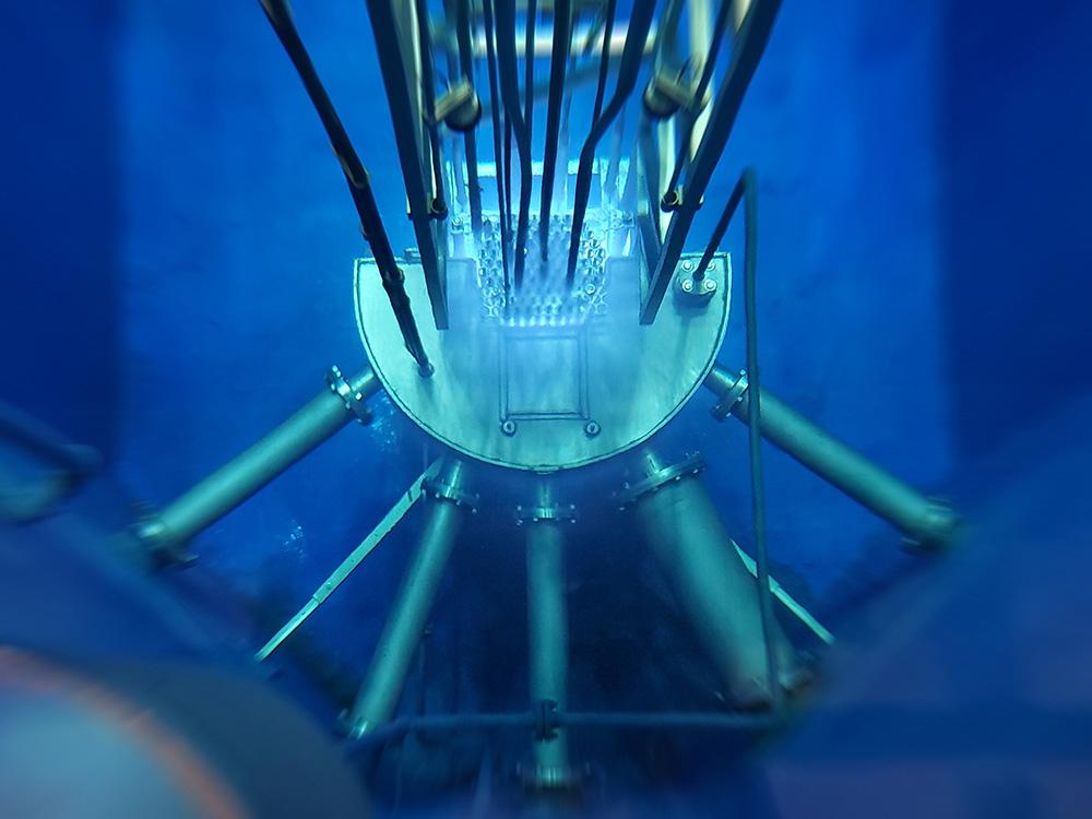 A metal contraption with five tubes sits in blue water.
