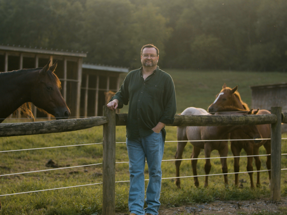  Andrew Sears, dean of the College of Information Sciences and Technology, stands in front of a pen of horses