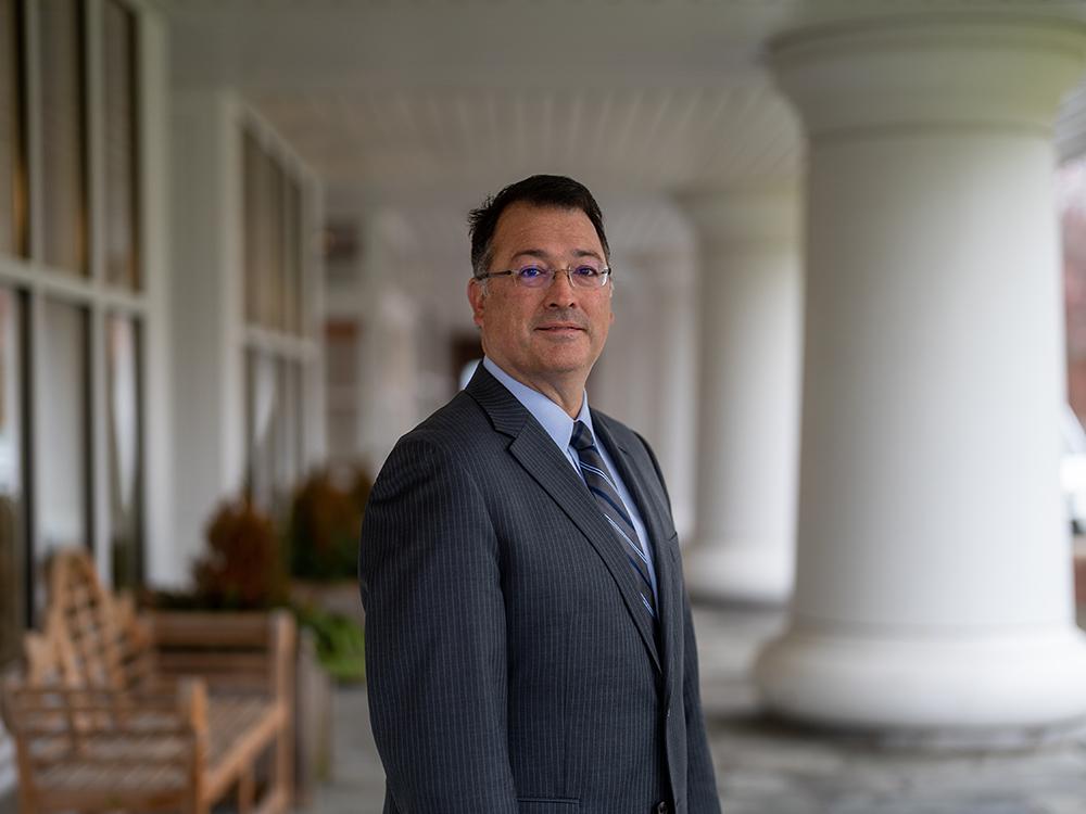 Head shot of dark-haired man wearing glasses and business suit.