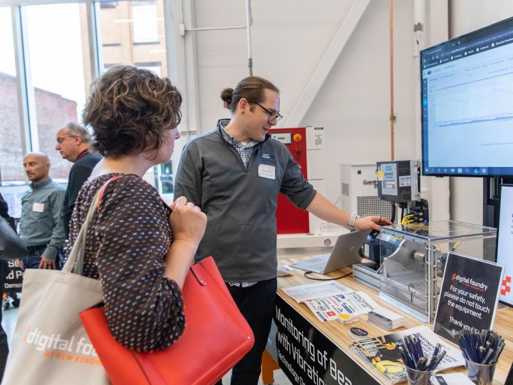 Man demonstrates technology to event attendee