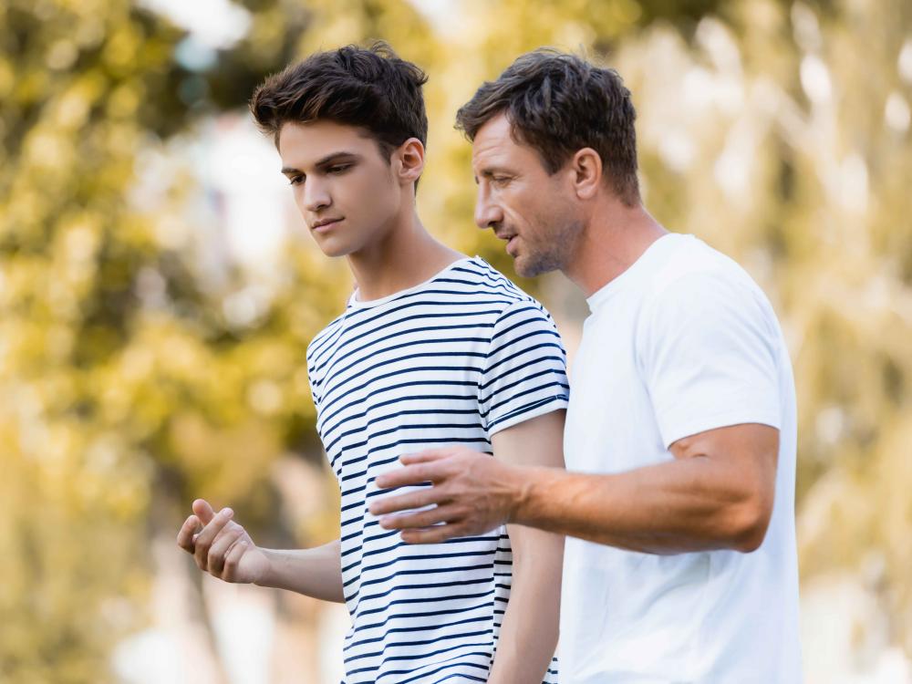 teen and father walking and talking together