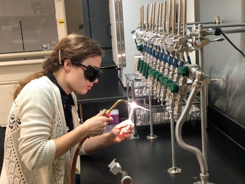 Maggie Davis sealing a quartz tube in the Radiocarbon Prep Laboratory