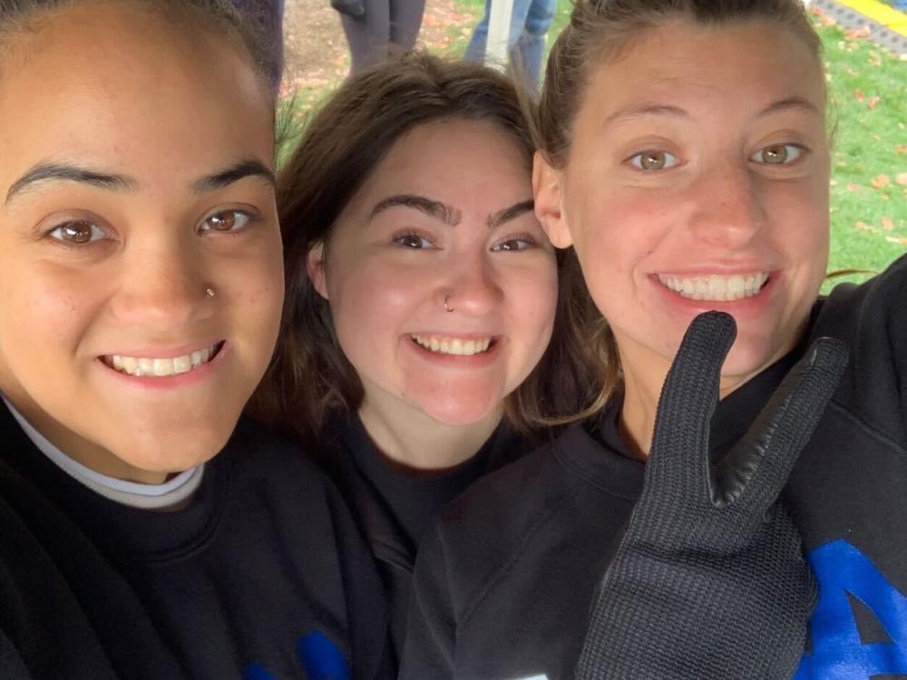 Three smiling students side by side