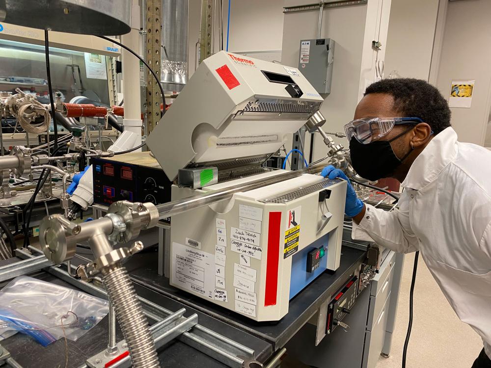 Man working in lab loading and reviewing a sample