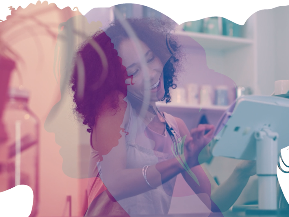 A Black woman smiling while operating a business inside a silhouette of women's heads.