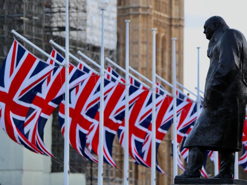 Statue of Winston Churchill in front of Union Jack Flags