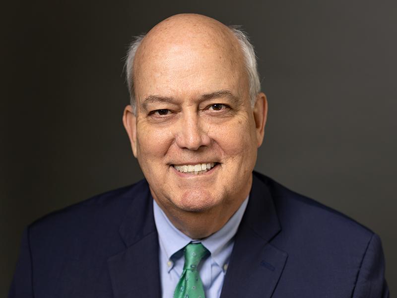 A photo of Bill Flanagan wearing a light blue shirt, green tie and navy blue tie. blue 