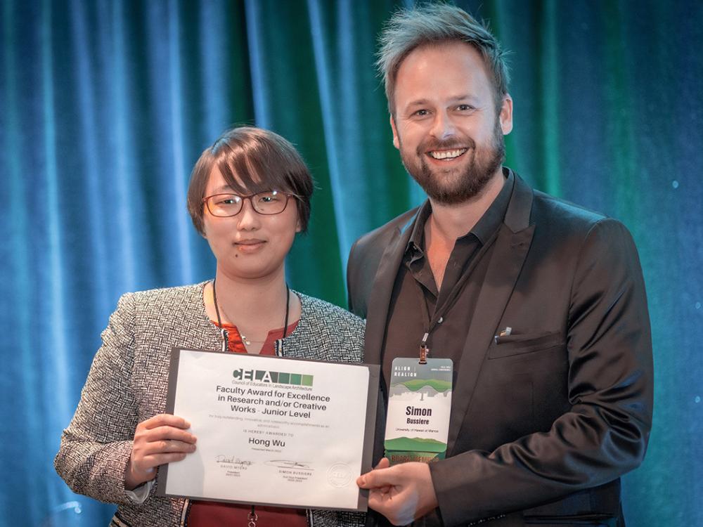 Hong Wu, at left, accepts her 2023 Excellence in Research and/or Creative Work Award from Simon M. Bussiere, second vice president of the Council of Educators in Landscape Architecture.