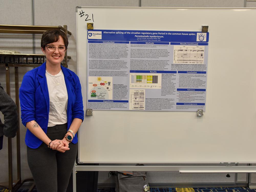 Female caucasian student standing in front of science display poster