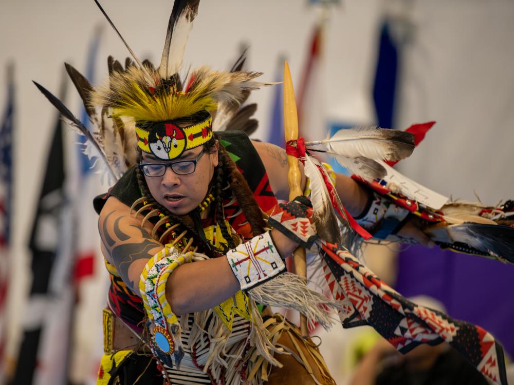 A dancer in traditional Native American clothing