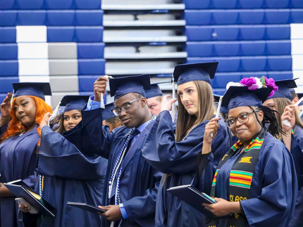 People in graduation caps moving their tassels